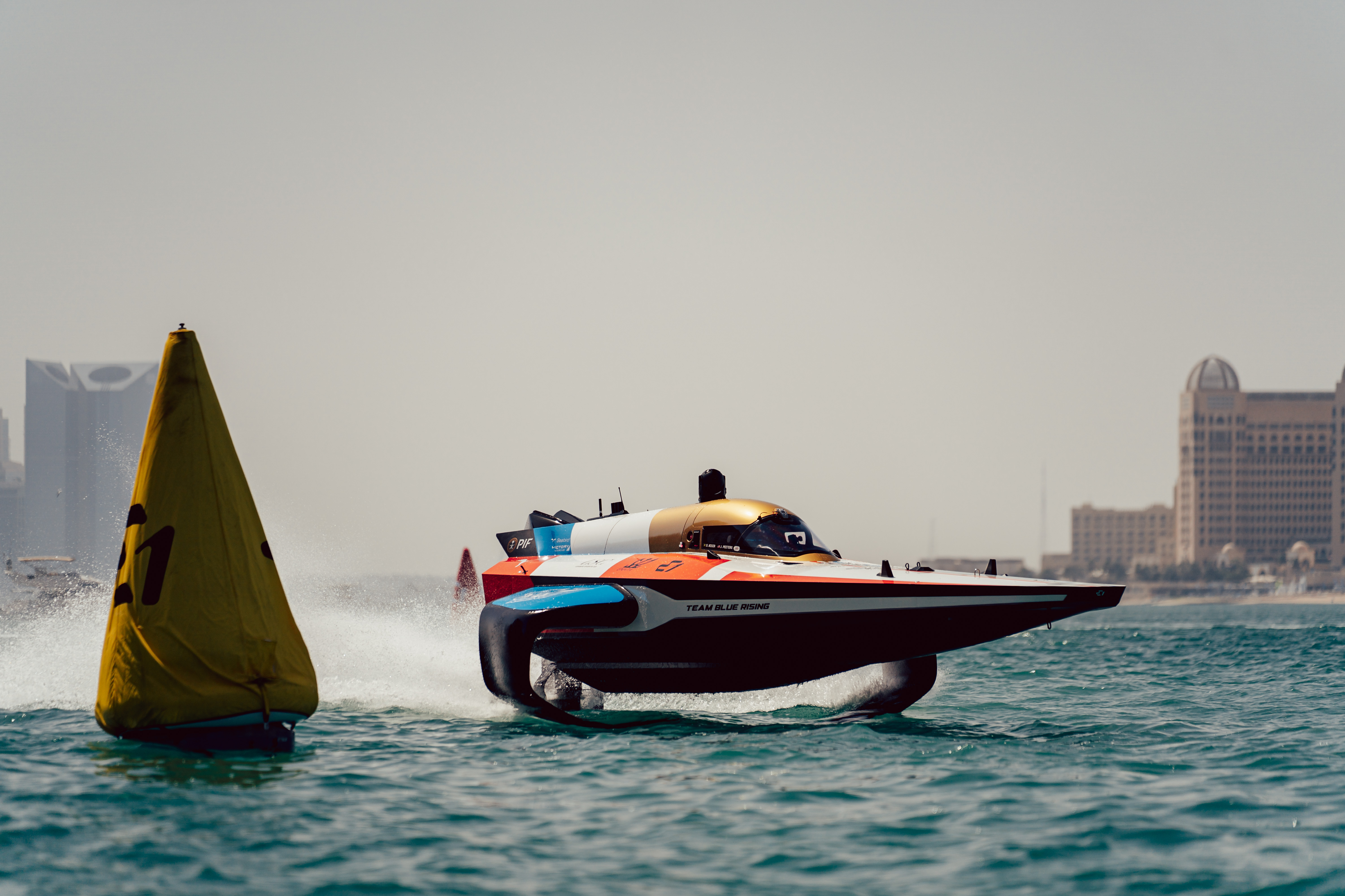 Team Blue Rising RaceBird hydrofoil racing past a course buoy